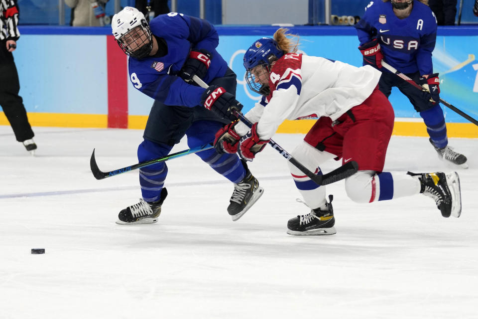 United States' Megan Bozek (9) and Czech Republic's Daniela Pejsova (4) battle for the puck during a women's quarterfinal hockey game at the 2022 Winter Olympics, Friday, Feb. 11, 2022, in Beijing. (AP Photo/Petr David Josek)