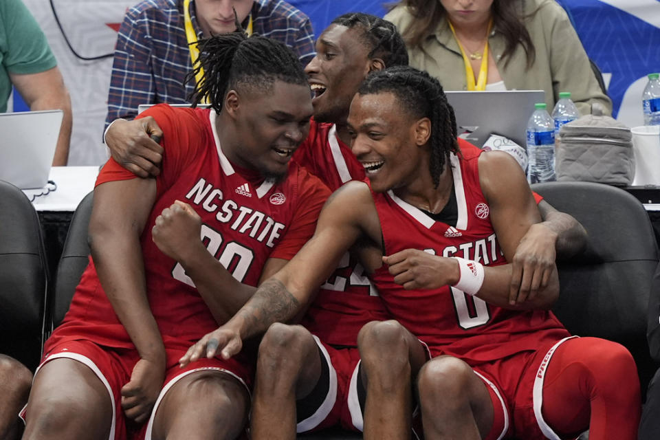 From l-r, North Carolina State players forward DJ Burns Jr. (30), forward Ernest Ross (24) and guard DJ Horne (0) celebrating in the final minute of the second half of an NCAA college basketball game against North Carolina in the championship of the Atlantic Coast Conference tournament, Saturday, March 16, 2024, in Washington. (AP Photo/Susan Walsh)