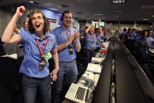 NASA's Kelley Clarke (L) celebrates as the first pictures appear on screen after the Curiosity rover successfully lands on Mars, breaking new ground in US-led exloration of the red planet