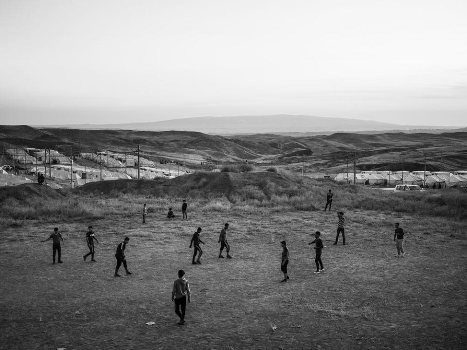 Refugees play soccer inside the Bardarash camp, which had hosted Iraqis displaced by the offensive against ISIS in Mosul and reopened in October to accommodate Kurds fleeing the Turkish offensive in Syria. | Moises Saman—Magnum Photos for TIME