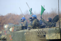 The crew of a Japanese Ground-Self Defense Force (JGDDF) Type 90 tank prepares for the maneuvers during an annual exercise at the Minami Eniwa Camp Tuesday, Dec. 7, 2021, in Eniwa, Japan's northern island of Hokkaido. Dozens of tanks are rolling over the next two weeks on Hokkaido, a main military stronghold for a country with perhaps the world's most little known yet powerful army. (AP Photo/Eugene Hoshiko)