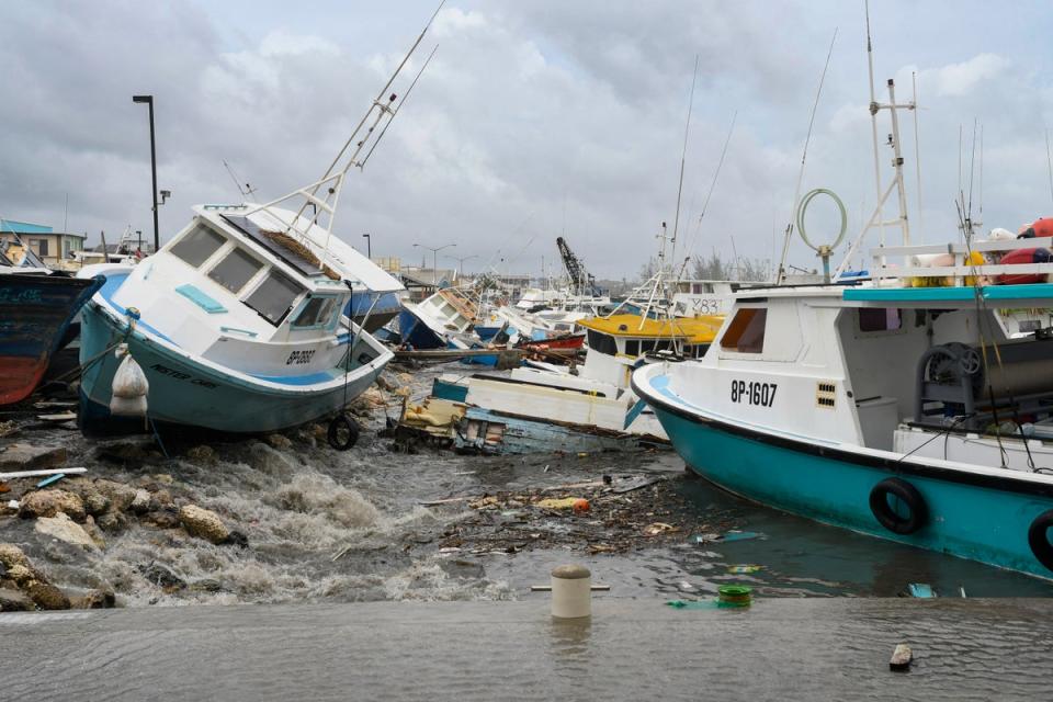 <p>Damaged fishing boats rest on the shore after the passing of Hurricane Beryl at the Bridgetown Fish Market, Bridgetown</p> (AFP via Getty Images)