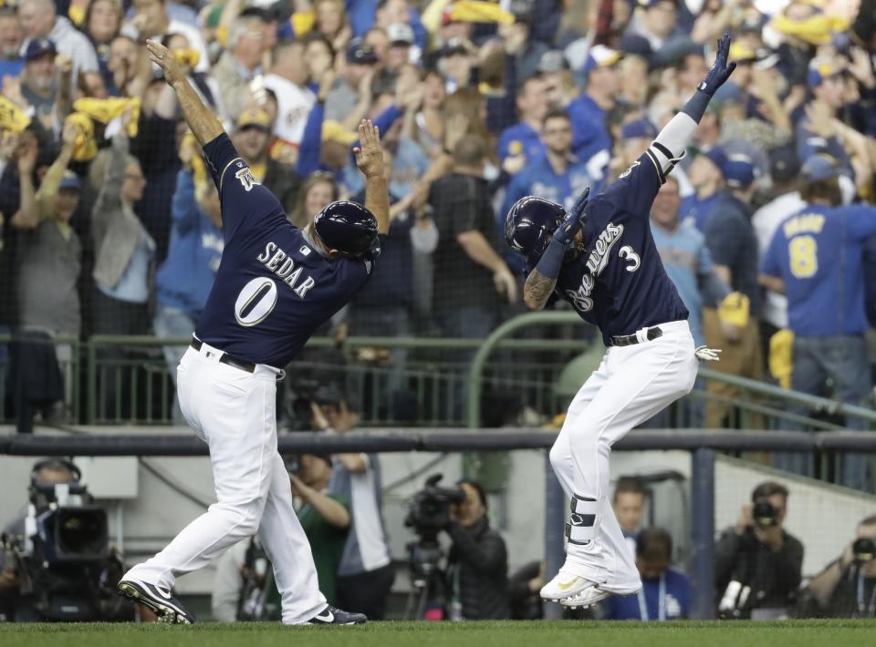 Milwaukee Brewers' Orlando Arcia celebrates his home run with third base coach Ed Sedar during the fifth inning of Game 2 of the National League Championship Series baseball game against the Los Angeles Dodgers Saturday, Oct. 13, 2018, in Milwaukee. (AP Photo/Matt Slocum)