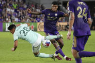 Atlanta United forward Tyler Wolff (28) gets tripped up as he goes for the ball against Orlando City midfielder Wilder Cartagena, center, during the second half of an MLS soccer match, Saturday, May 27, 2023, in Orlando, Fla. (AP Photo/John Raoux)