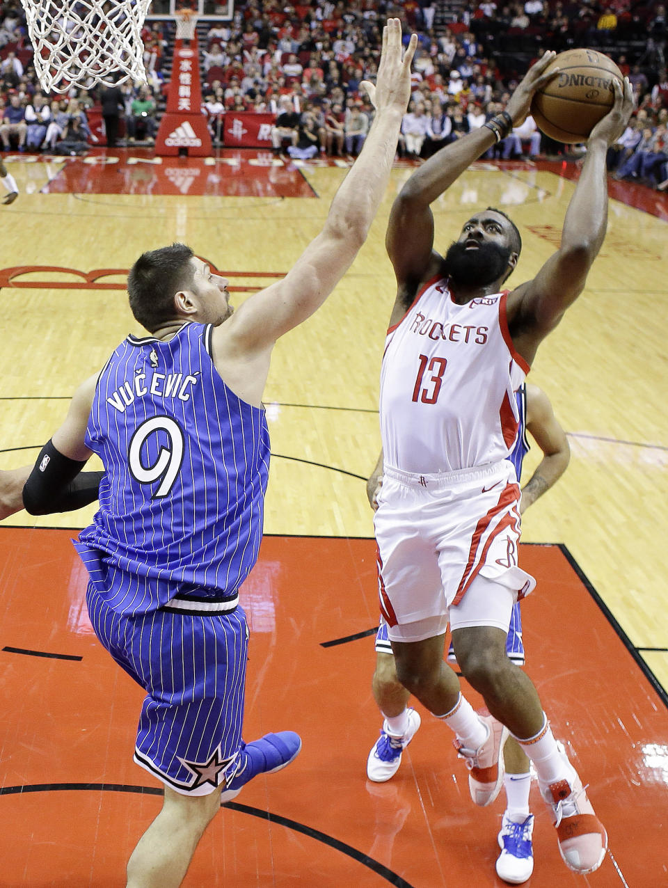 Houston Rockets guard James Harden, right, drives to the basket as Orlando Magic center Nikola Vucevic, left, defends during the first half of an NBA basketball game, Sunday, Jan. 27, 2019, in Houston. (AP Photo/Eric Christian Smith)