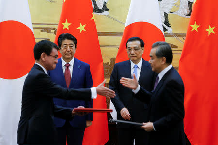 Chinese Premier Li Keqiang, Japanese Prime Minister Shinzo Abe, Chinese Foreign Minister Wang Yi and Japanese Foreign Minister Taro Kono attend a signing ceremony at the Great Hall of the People in Beijing, China October 26, 2018. REUTERS/Thomas Peter
