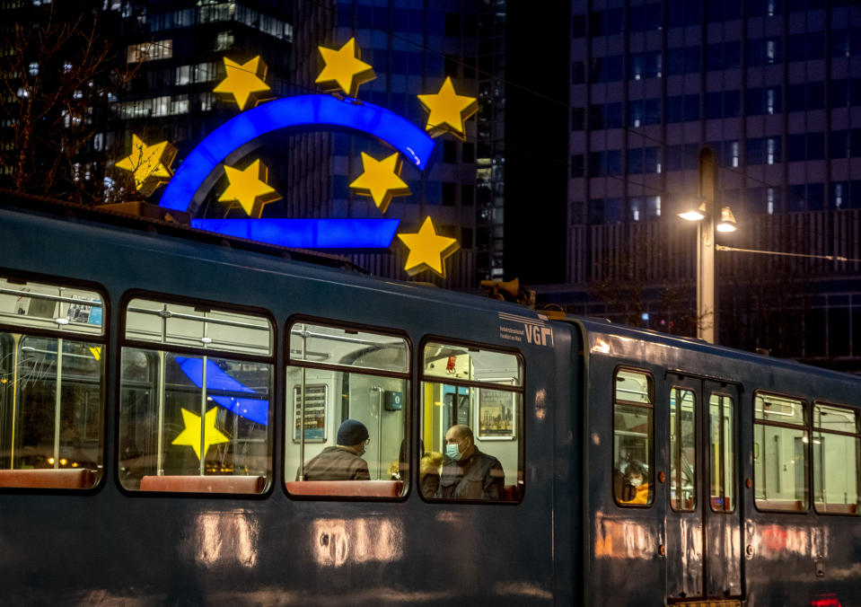 People in a tram pass the Euro sculpture in Frankfurt, Germany, Thursday, March 11, 2021. The European Central Bank will have a meeting of the governing council on Thursday. (AP Photo/Michael Probst)