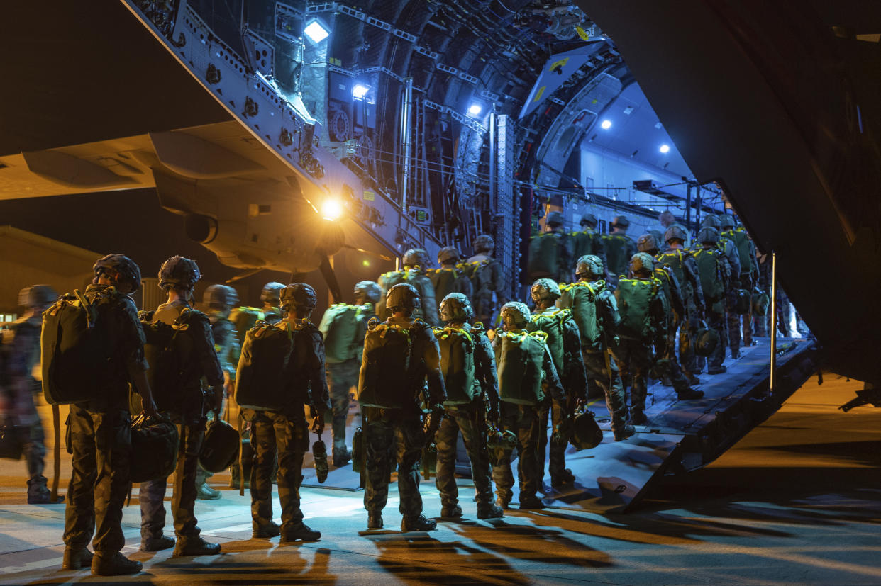 Soldiers board a military plane.