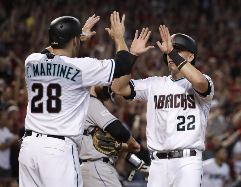 Arizona Diamondbacks’ J.D. Martinez (28) high-fives Jake Lamb (22) after they scored on a two-run triple by A.J. Pollock during the eighth inning of the National League wild-card game against Colorado. (AP)