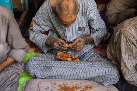 A displaced Iraqi man who was among the rescued at the site of battle eats bread at the positions of Iraqi forces at the Old City in Mosul, Iraq. REUTERS/Erik De Castro