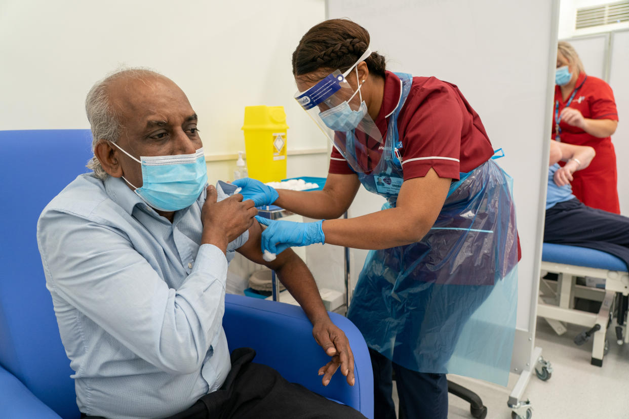 Care home worker Pillay Jagambrun, 61, receives the Pfizer-BioNTech Covid-19 vaccine in The Vaccination Hub at Croydon University Hospital, south London, on the first day of the largest immunisation programme in the UK's history. Care home workers, NHS staff and people aged 80 and over began receiving the jab this morning.