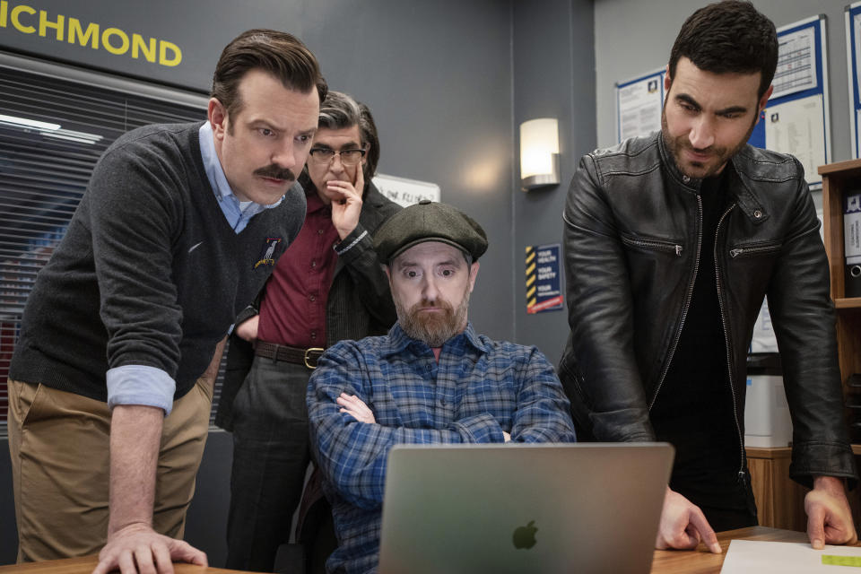 En esta imagen difundida por Apple TV+, Jason Sudeikis, de izquierda a derecha, James Lance, Brendan Hunt y Brett Goldstein en una escena de "Ted Lasso". (Colin Hutton/Apple TV+ vía AP)