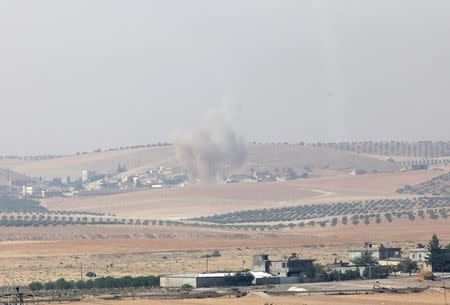 Smoke rises from the Syrian border town of Jarablus as it is pictured from the Turkish town of Karkamis, in the southeastern Gaziantep province, Turkey, August 24, 2016. REUTERS/Stringer