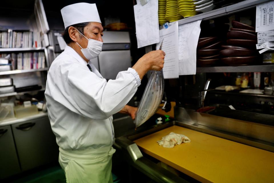 Noriaki Ito, prepares to slice raw katsuo (Reuters)