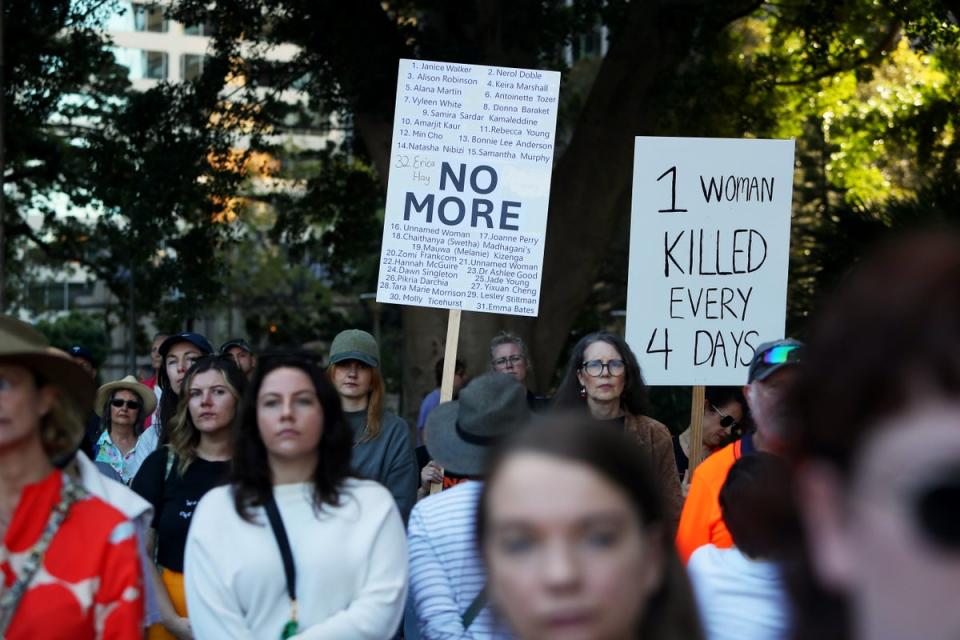 Demonstrators hold placards at rally in Sydney (Getty)