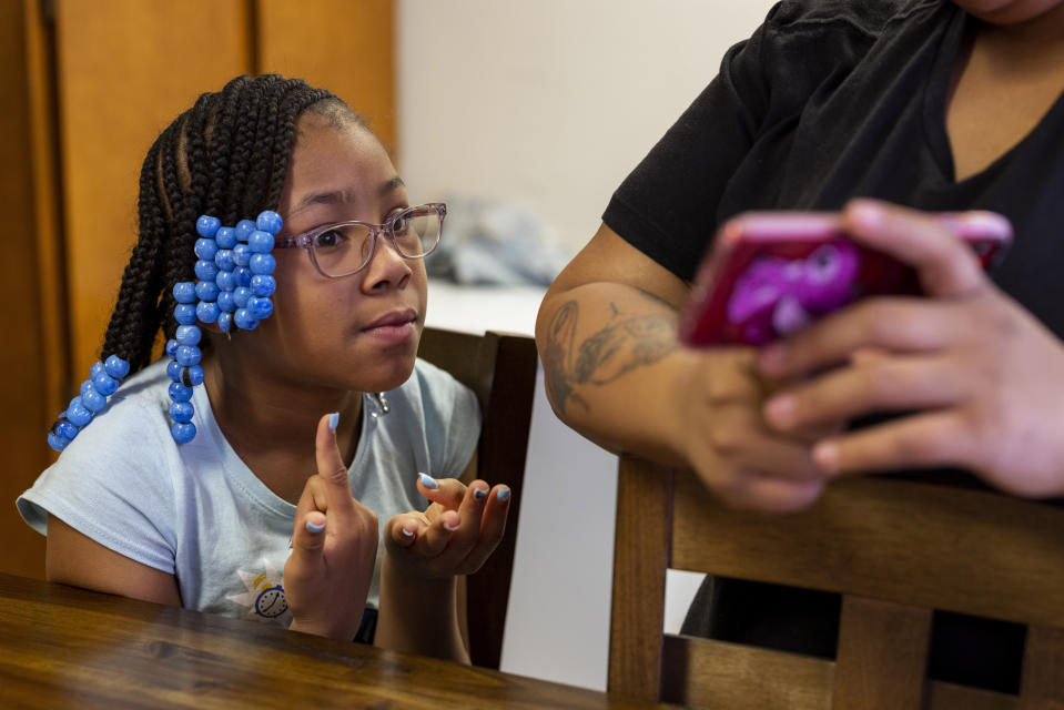 Ke'Arrah Jessie, 9, counts on her fingers while being quizzed on multiplication by her mom in their kitchen in Niagara Falls, N.Y., on Monday, April 3, 2023. Ke’Arrah likes math and wants to be a police officer. (AP Photo/Lauren Petracca)