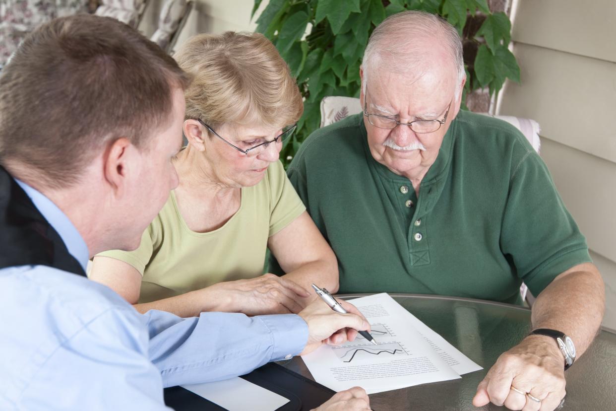 financial advisor reviewing documents with elderly couple