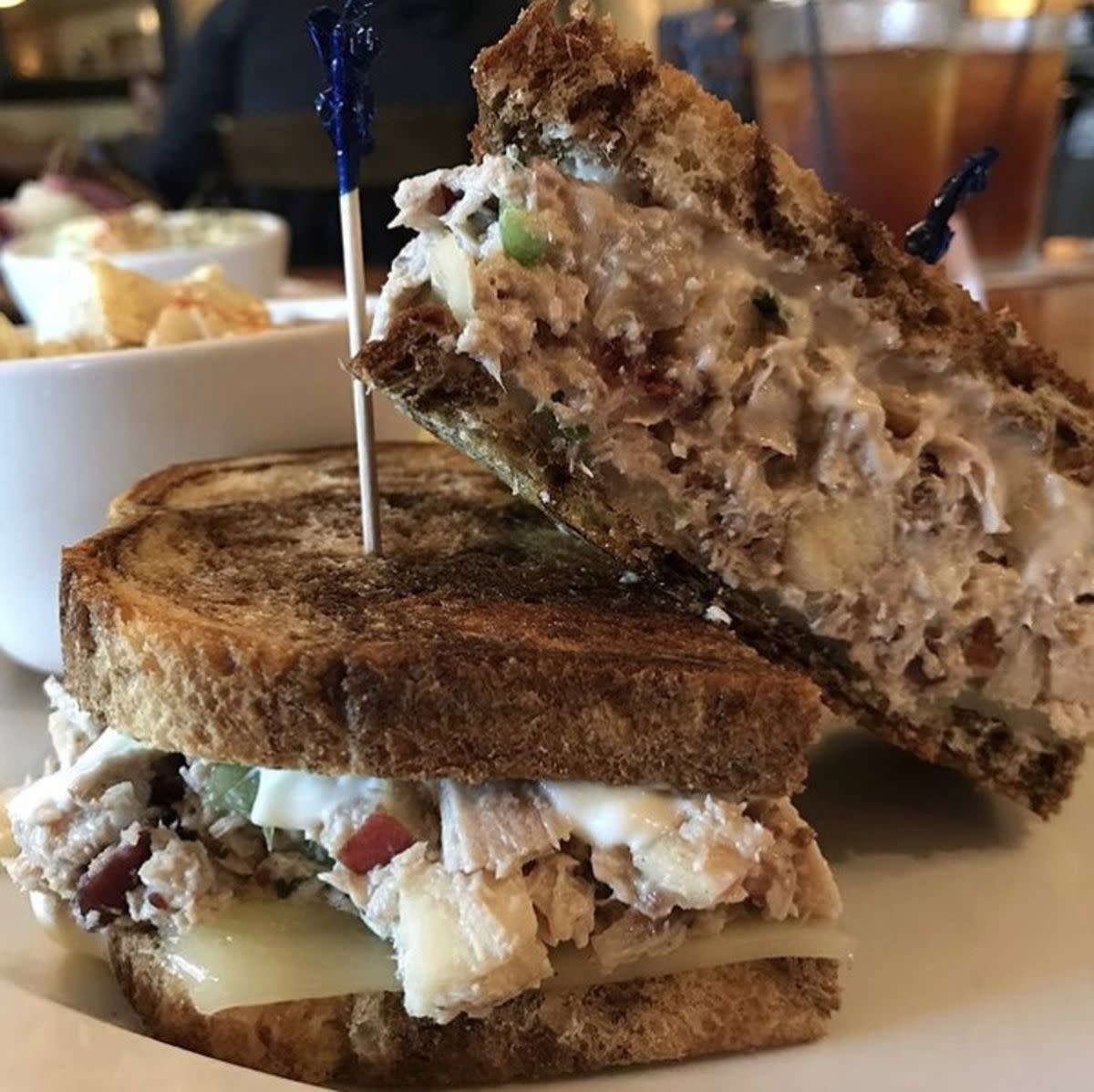 Closeup of Pheasant Salad Sandwich on a ceramic plate, The Pheasant Restaurant & Lounge, Brookings, South Dakota, with sides blurred in the background