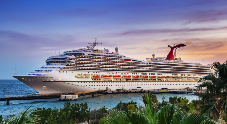 Cruise ship Carnival Conquest docked at port Willemstad on sunset. Cruise stocks.