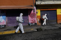 Personal sanitario rocía una solución desinfectante en una calle de San Gregorio Atlapulco, en el delegación Xochimilco de Ciudad de México, el viernes 24 de julio de 2020, en medio de la pandemia del nuevo coronavirus. (AP Foto/Rebecca Blackwell)