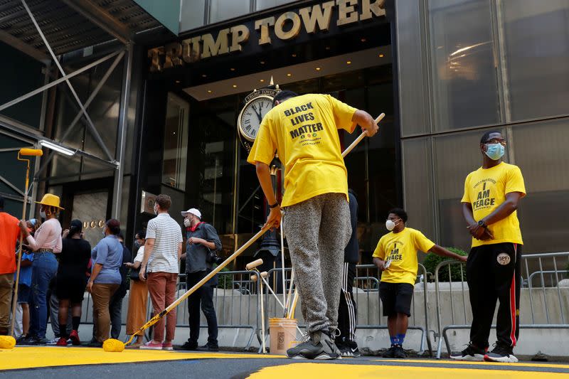 People paint "Black Lives Matter" along 5th avenue outside Trump Tower in New York City