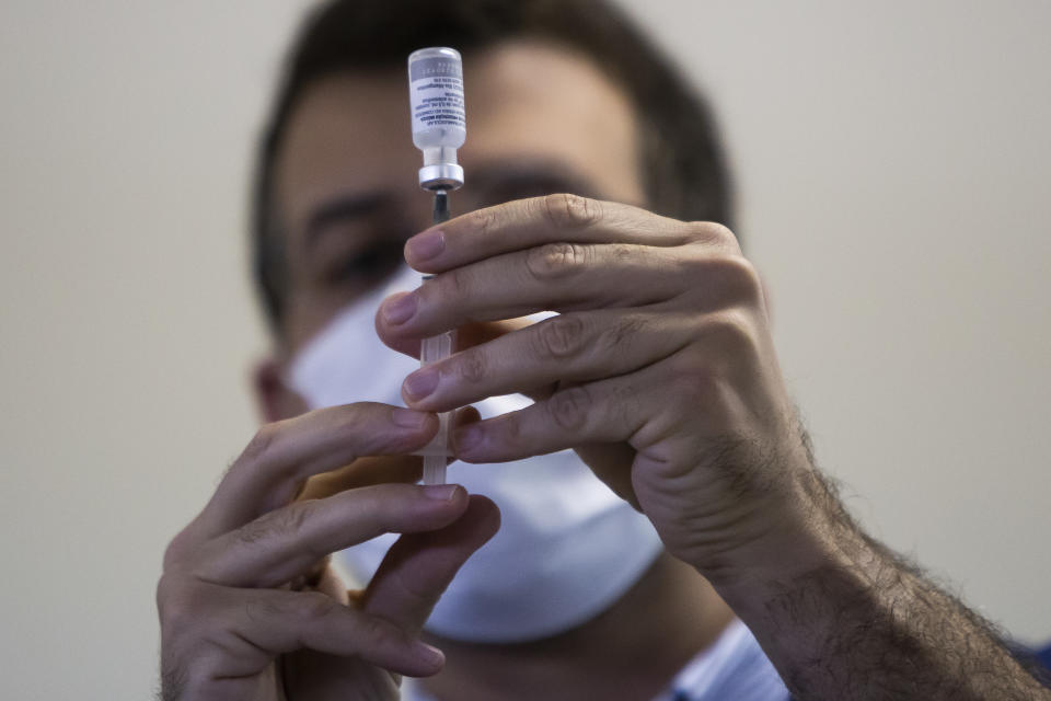 A health worker prepares a dose of the Oxford-AstraZeneca vaccine. Photo: Bruna Prado/AP
