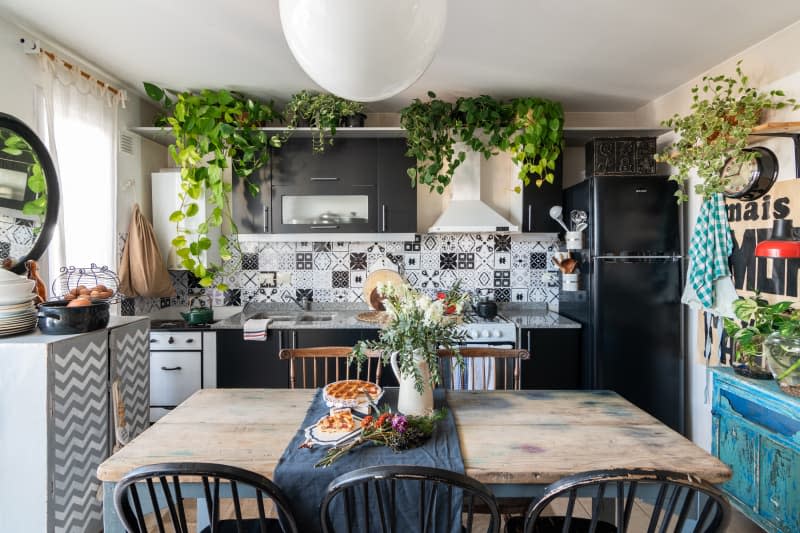 A black and white kitchen with a wooden dining table