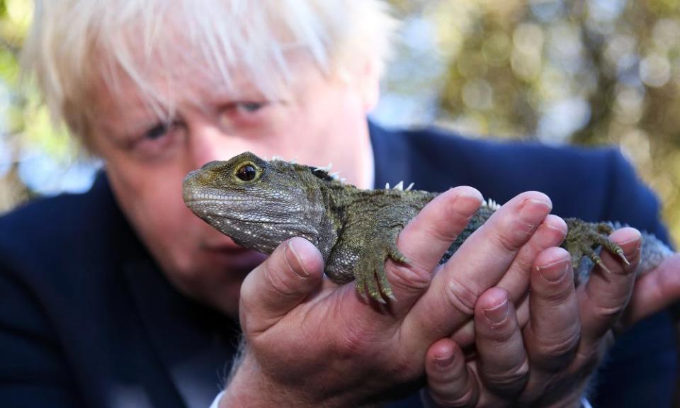 Boris Johnson holds a tuatara reptile in New Zealand