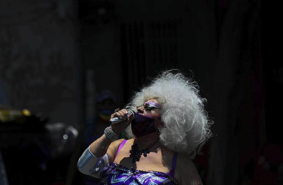 En esta imagen, tomada el 25 de mayo de 2020, una drag queen que toma el nombre y el estilo de la famosa actriz, cantante y drag estadounidense Devine, actúa durante un programa creado por activistas LGTB para gente que no ha podido trabajar por la pandemia del COVID-19, en la Ciudad de México. (AP Foto/Fernando Llano)