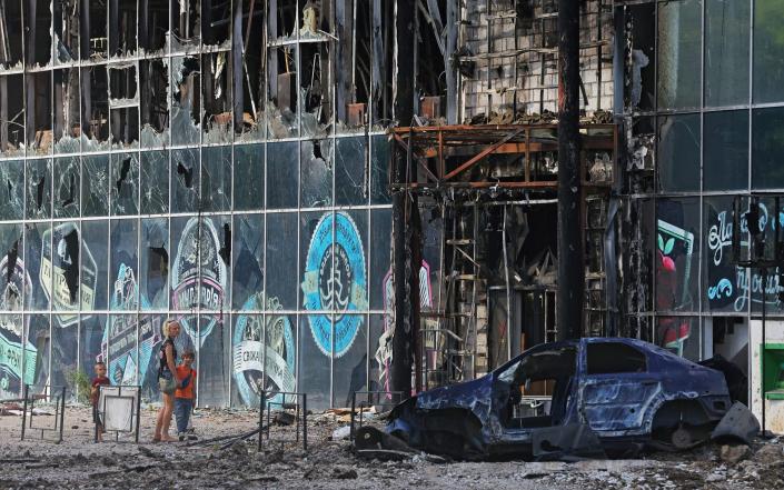 Local residents next to a building destroyed during Ukraine-Russia conflict in the city of Lysychansk in the Luhansk Region - Alexander Ermochenko/Reuters