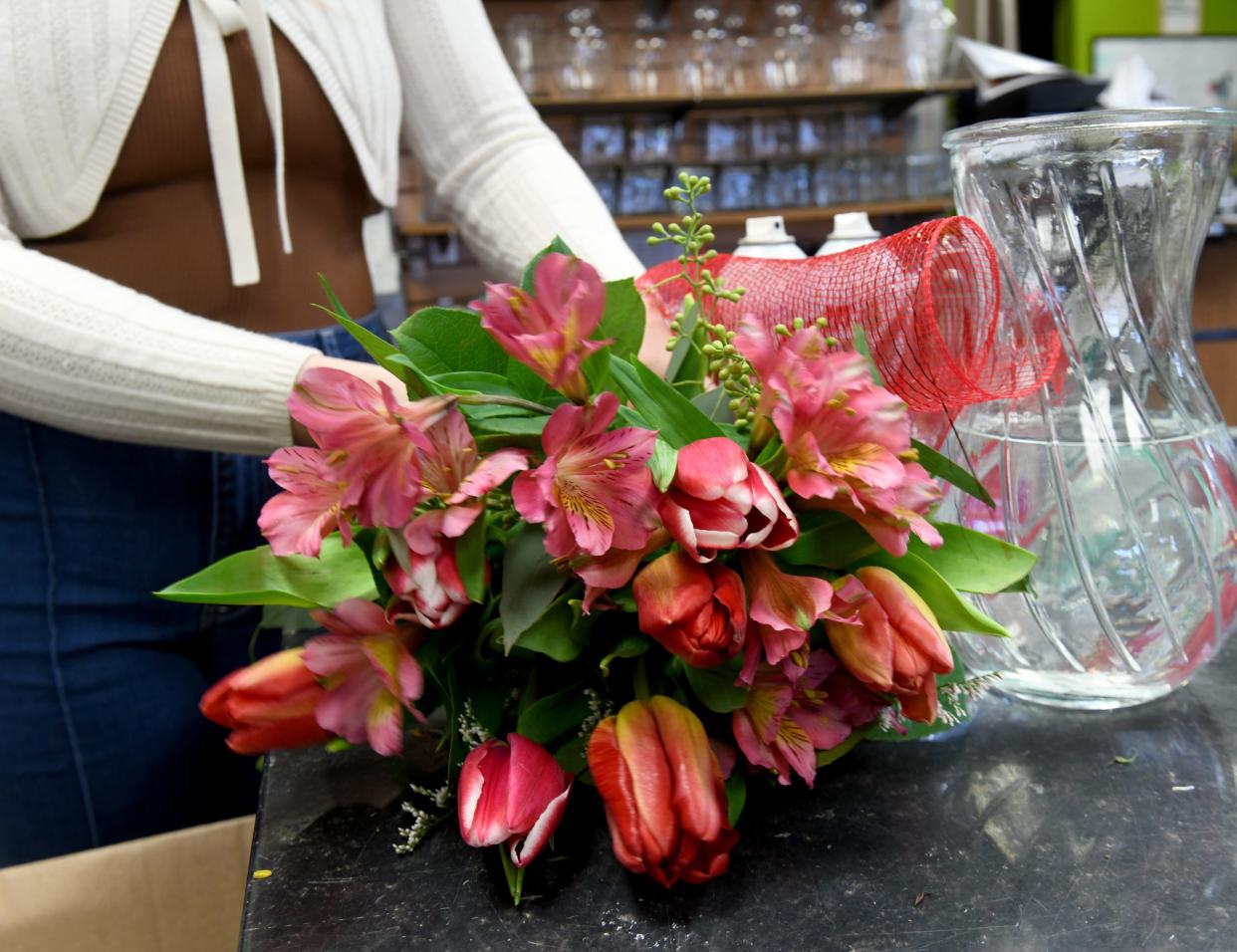Aleah McKenney-Hartley, co-owner of Botanica Florist in Jackson Township, creates an arrangement from fresh flowers.
