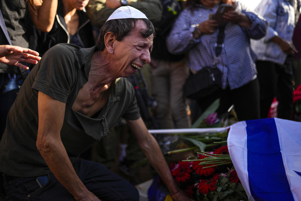 A man mourns during the funeral of Antonio Macias, killed by Hamas militants while attending a music festival in southern Israel, at Pardes Haim cemetery in Kfar Saba, Israel, Sunday, Oct. 15, 2023. (AP Photo/Francisco Seco)