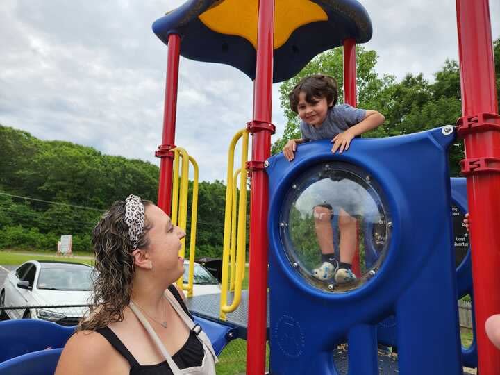 Child care worker Kayla Champagne watches her son, Jaxson, 3, climb at the Little Learners Academy in Smithfield, R.I. (Elaine S. Povich/Stateline)