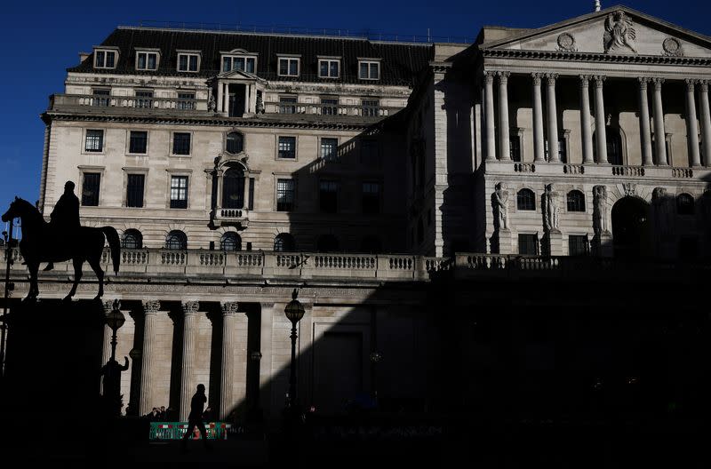 FILE PHOTO: A person walks outside the Bank of England in the City of London financial district in London