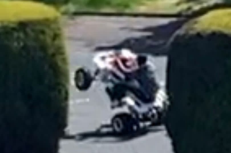 A biker riding 'hands free' at Ainley Top while apparently holding something - possibly a mobile phone
