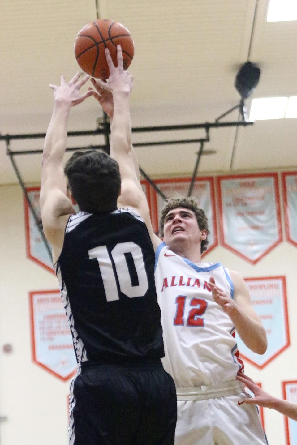 Alliance's Brendan Zurbrugg (12) puts up a shot over Carrollton defender Luke Allison during conference action at Alliance High School on Tuesday.