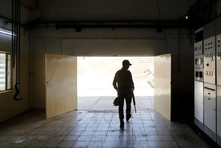 An Iraqi security officer stands guard during the inaugration of a water treatment plant on the outskirts of Qaraqosh, Iraq, May 7, 2017. Picture taken May 7, 2017. REUTERS/Danish Siddiqui