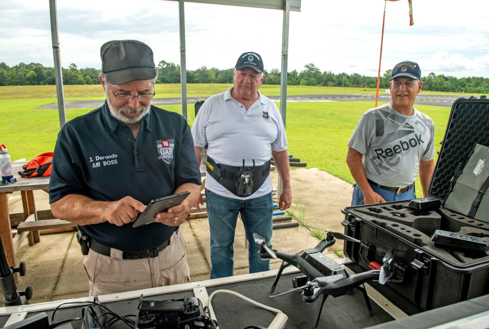 Drone instructor Joseph Dorando gets drones ready for flight as students Pat Rushing and Felix Rivera look on Monday at the Escambia RC Model Park. The students are part of a Wounded Eagle UAS program that teaches wounded and disabled veterans how to operate and repair drones, as well as earn an FAA or commercial drone driver's license.