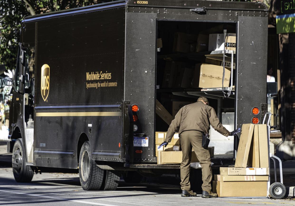 A UPS driver making deliveries in downtown Traverse City, Michigan. UPS is a package and letter delivery service with operations around the world.