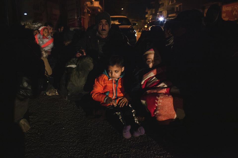 Migrants from Syria and Iraq wanting to register for asylum, sit on the road in Orestiada town, northeastern Greece, Monday, April 22, 2019. Greek authorities say dozens of asylum-seekers have turned up at the front door of European border agency employees helping police Greece's northeastern border with Turkey. (AP Photo/Antonis Pasvantis)