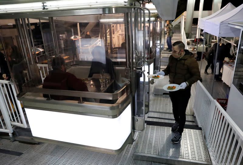 A waiter serves customers as Michelin-starred restaurant Costes moves into the Budapest Eye ferris wheel during the coronavirus outbreak