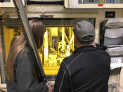 In this Nov. 29, 2018 photo, hot cell operators Dawnette Hunter, left, and Scot White manipulate radioactive material from behind 4-foot-thick leaded glass at the Hot Fuel Examination Facility at the Idaho National Laboratory about 50 miles west of Idaho Falls, Idaho. (AP Photo/Keith Riddler)