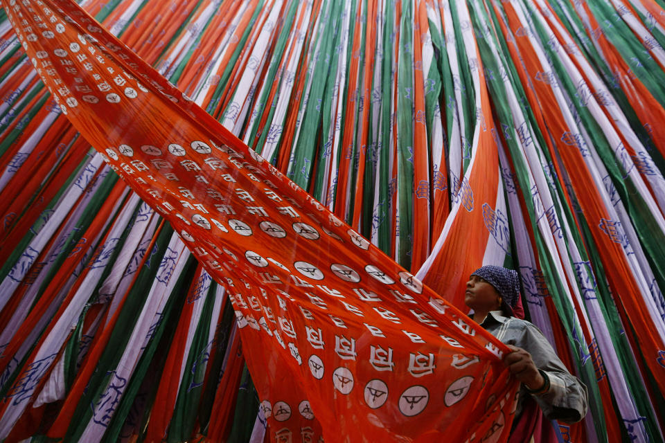 FILE - In this Monday, March 25, 2019 file photo, a worker prepares election campaign material for Indian political parties ahead of elections in Ahmadabad, India. The final phase of India’s marathon general election will be held on Sunday, May 19. The first of the election’s seven staggered phases was held on April 11. Vote counting is scheduled to start on May 23. India has 900 million eligible voters. (AP Photo/Ajit Solanki, File)