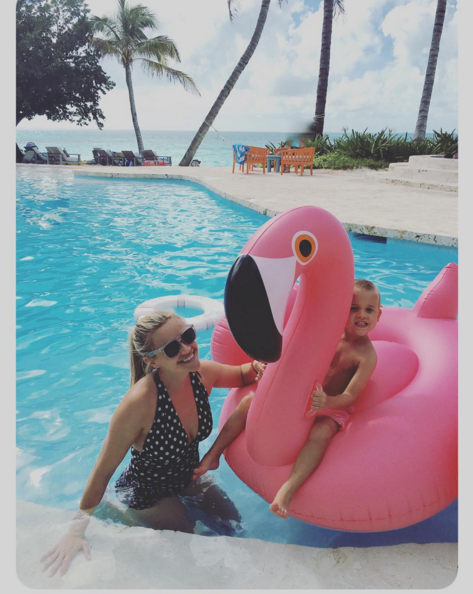 Reese Witherspoon (with her son, Tennessee) wears a polka dot one piece in the pool. 