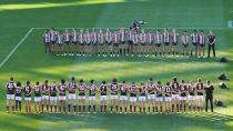 Collingwood and Essendon players show their respects at the MCG.