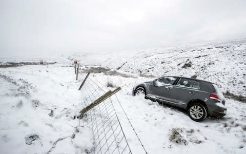 An abandoned car on the roadside in the Peak District after heavy snowfall - Credit: Danny Lawson /PA