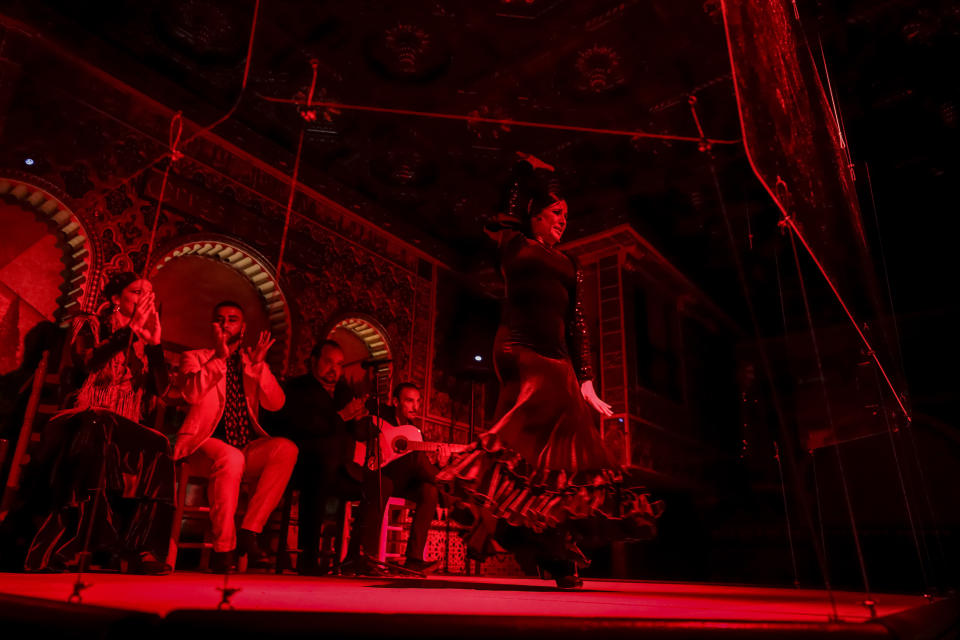 Flamenco dancer Antonia Estepa performs behind screens next to hand clappers and guitarists during a flamenco show at the Torres Bermejas "tablao," or live flamenco venue, in Madrid, Spain, Friday, Sept. 25, 2020. The passion and drama of live flamenco shows are back on stage in Madrid. But now the performers are behind Perspex screens and keeping their distance from the audience. The Torres Bermejas “tablao,” or live flamenco venue, has reopened its doors to customers after seven months closed due to the COVID-19 pandemic. (AP Photo/Manu Fernandez)