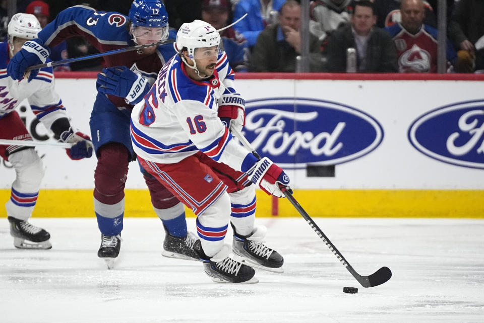 New York Rangers center Vincent Trocheck, front, collects the puck as Colorado Avalanche center Yakov Trenin defends during the second period of an NHL hockey game Thursday, March 28, 2024, in Denver. (AP Photo/David Zalubowski)