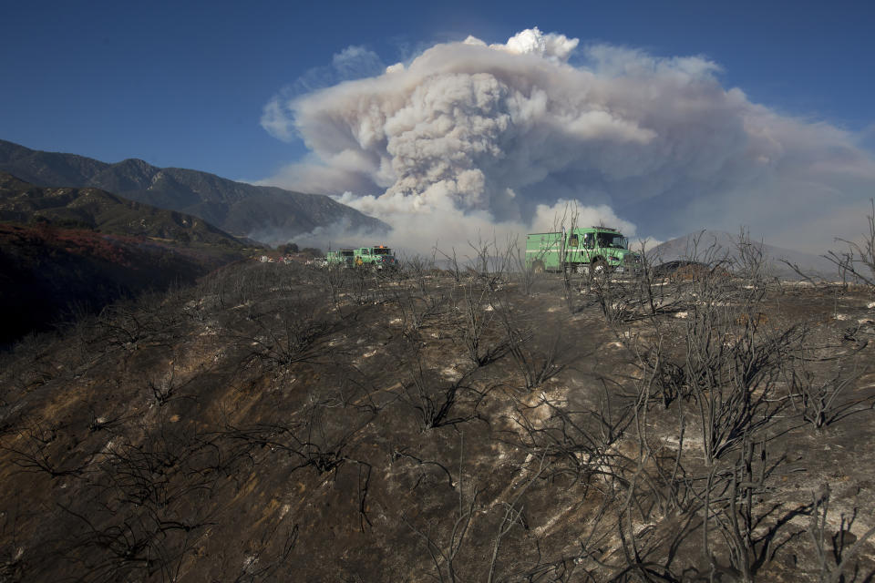 Some rises behind an area burned by a brush fire at the Apple Fire in Cherry Valley, Calif., Saturday, Aug. 1, 2020. (AP Photo/Ringo H.W. Chiu)