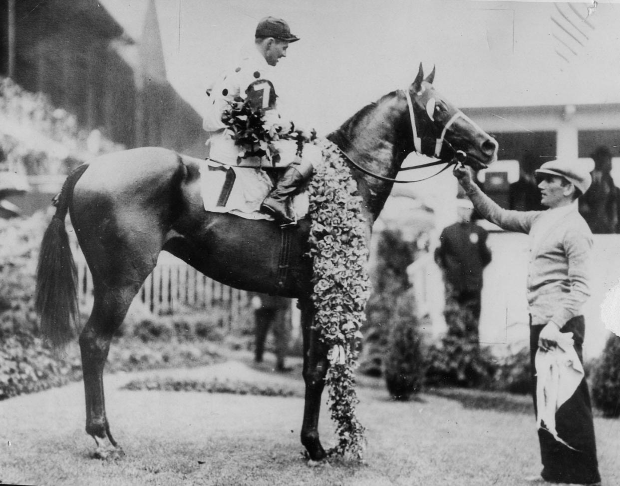 Gallant Fox, with jockey Earl Sande aboard, wins the Kentucky Derby at Churchill Downs in 1930. Gallant Fox would go on to become the second Triple Crown winner in history. James Fitzsimmons trained Gallant Fox, as well as his son, Omaha, which won the Triple Crown in 1935.